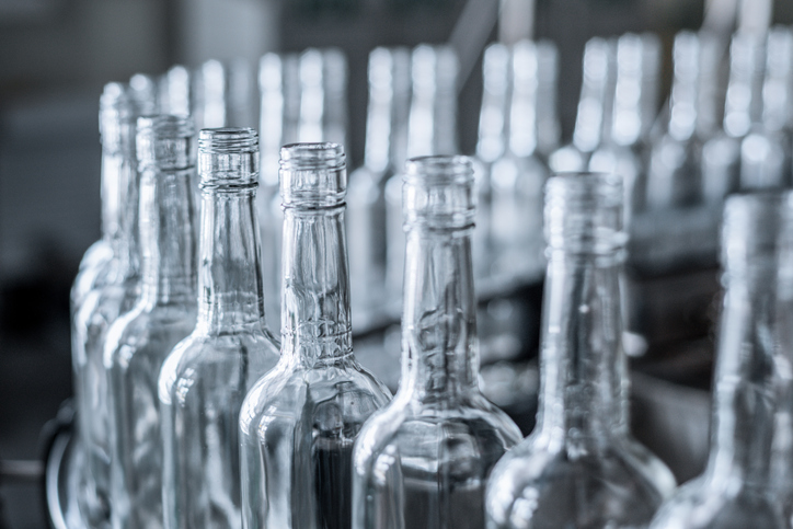 Glass bottles in production waiting for laser based defect inspection